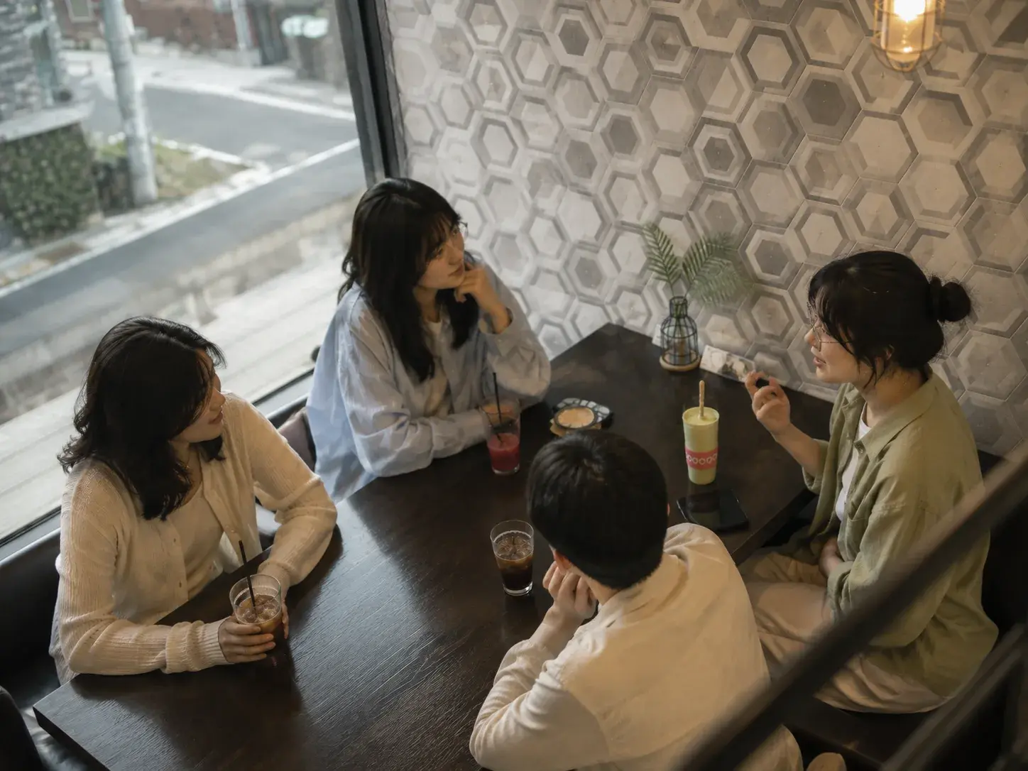 신입 구성원 네 명이 테이블에 둘러앉아 이야기를 나누는 모습